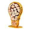 An isometric view of one of Ardour's light bulb shaped metal log baskets in honey yellow. It is a profile of a screw-in style light bulb attached to a base-plate. The design has two compartments; A small one at the top to store kindling and a large one for the main body of the bulb to store the logs.